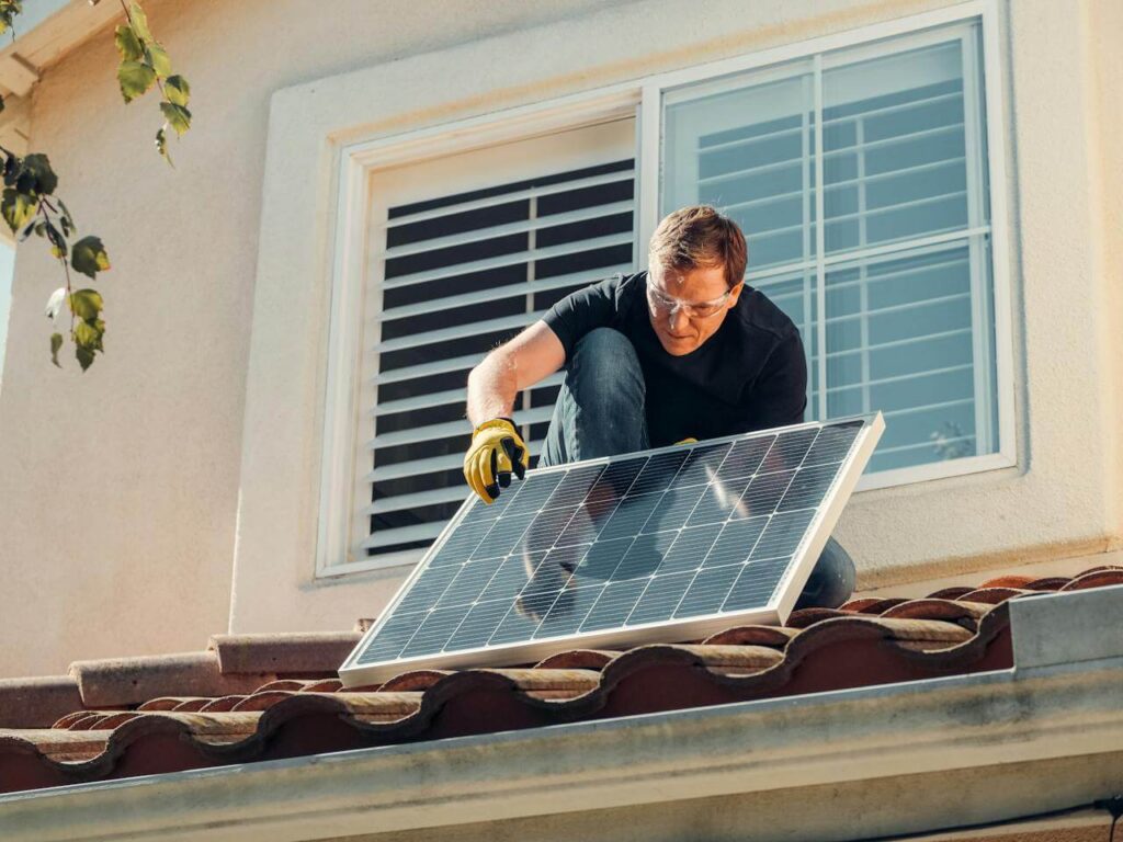 Instalador fotovoltaico montando placas solares en una cubierta
